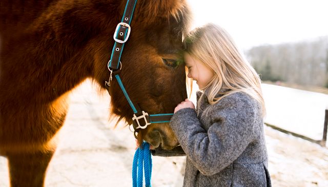Flicka som myser med sin häst