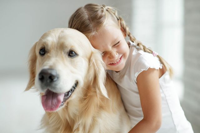 Mädchen kuschelt mit ihrem Hund.