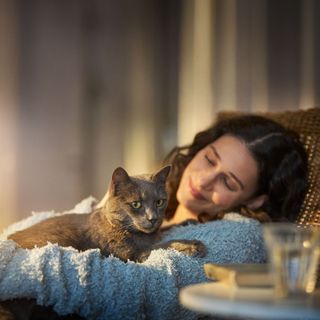 Cornelia drückt ihre Katze im Sessel an sich.