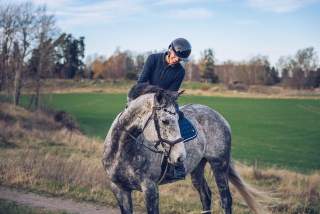 Pferd und Mensch bei Ausritt auf dem Feld.