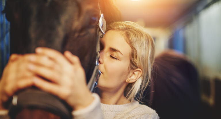 Mädchen, das ihr Pferd umarmt.