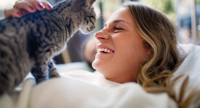 Frau umarmt mit Katze